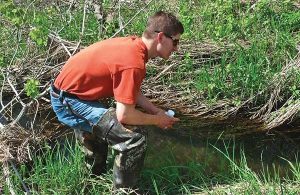 A man testing for Phosphorus in a stream