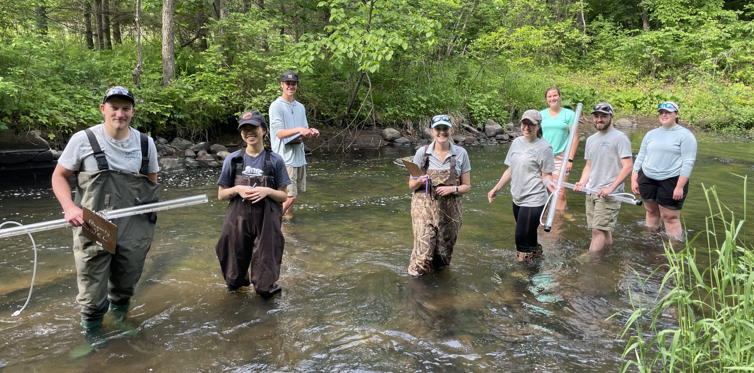 Volunteers standing in a shallow stream